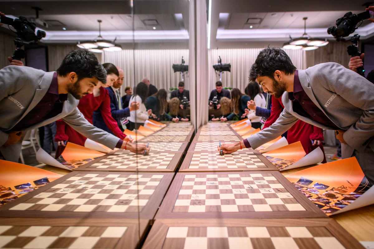 Gukesh signing chessboards at the 2024 Candidates tournament