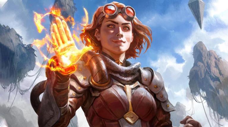 Chandra Nalaar from Magic The Gathering holds up one flaming hand in a greeting.