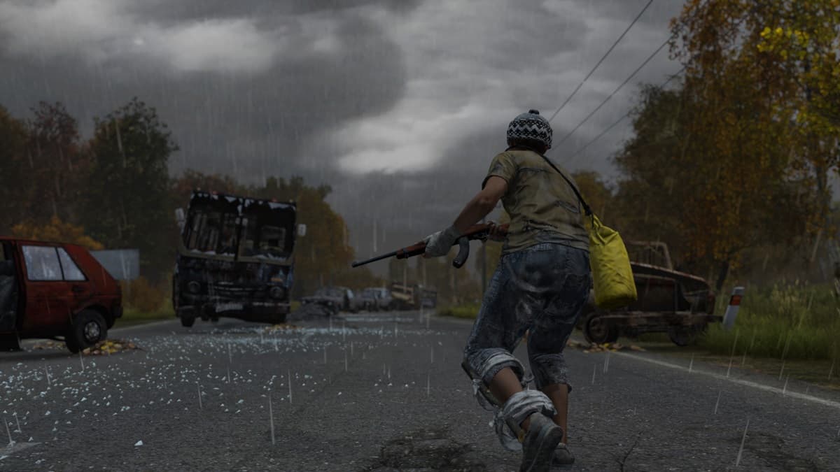 Player character running through an abandoned road, gun in hand with ruined vehicles in the background