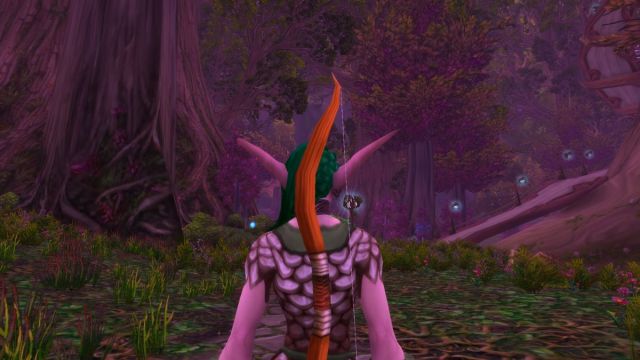 Night Elf Hunter facing the forest in World of Warcraft with pointy ears and a bow.