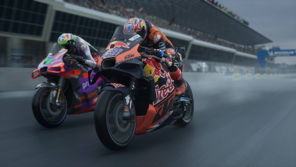 Two sports bikes racing against each other on a track in a stadium