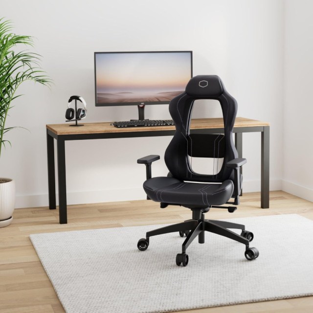 The Cooler Master Hybrid 1 in a bright home office setting. It is a rolling racer seat made of black synthetic leather with a thick headrest, cushioned wings, mesh backrest, and thick seat. More details below.