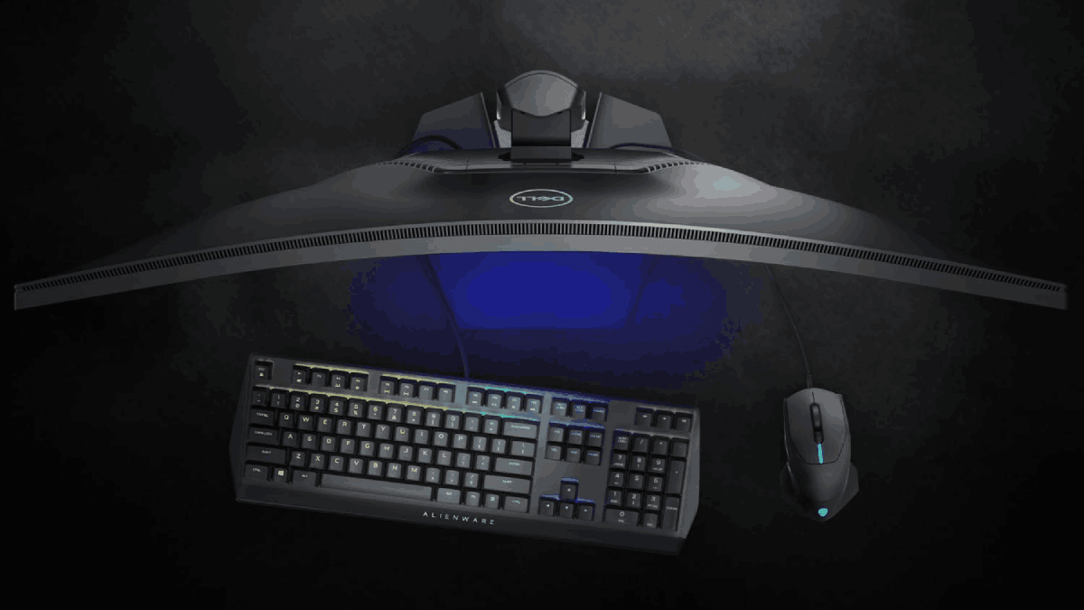 Top down shot of a curved monitor emitting a soft blue light, keyboard, and mouse.