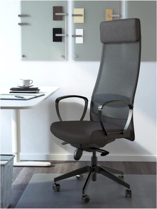 The IKEA MARKUS in a corporate office setting. It has a tall backrest with a wide cushioned headrest, two loop-shaped armrests, and a cushioned seat. More details below.