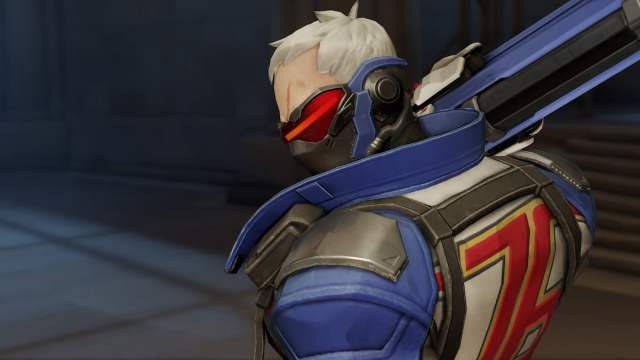 Soldier: 76 wearing blue clothing with a red visor, holds a rifle on his shoulder.