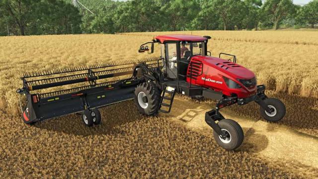 An image of the MacDon tractor clearing a wheat field in Farming Simulator 25. This is a red tractor with the MacDon logo.