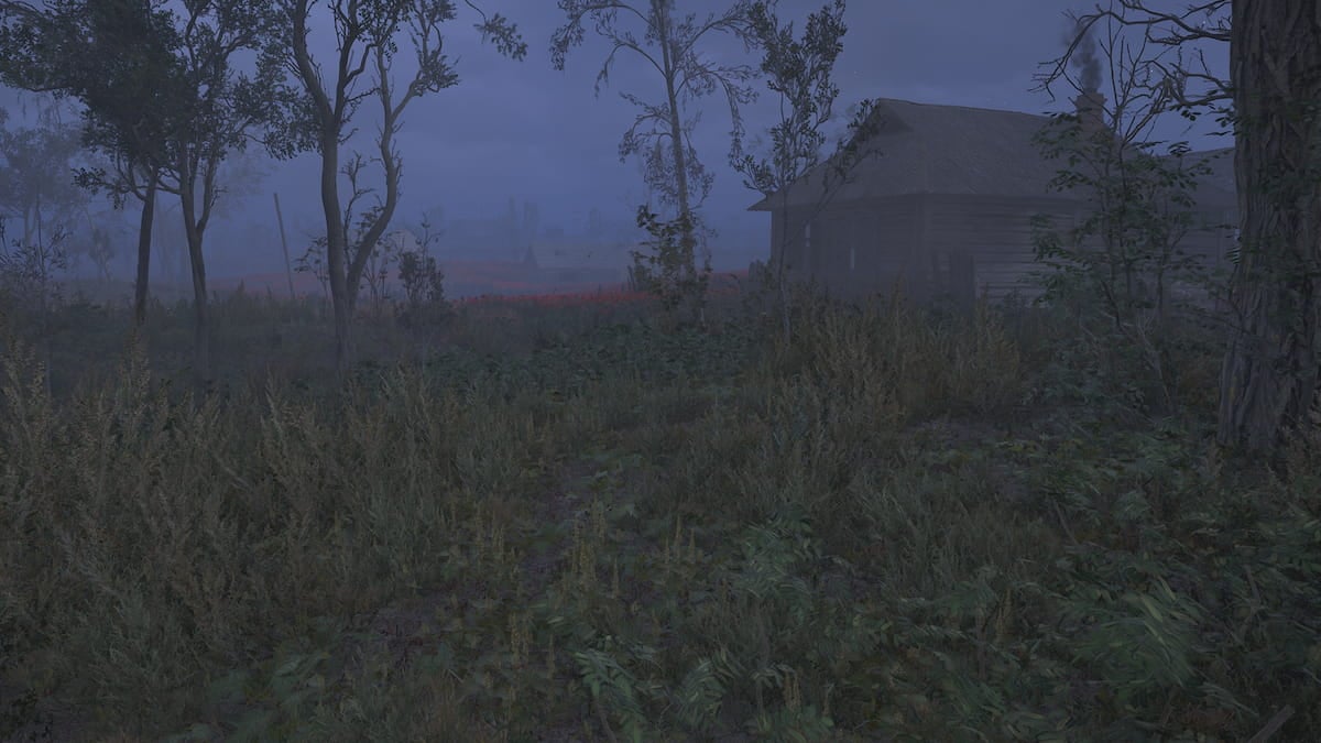 A dark, foggy field with the shadows of trees and a small building in the distance.