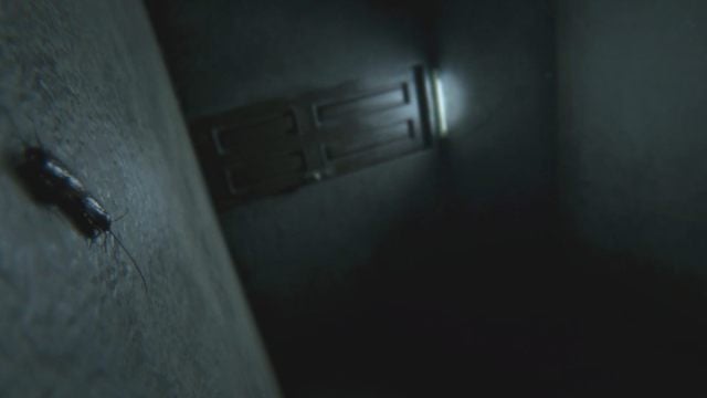 A side shot of protagonist waking up in first-person perspective showing a single door and two cockroaches mating on the floor