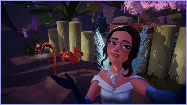 An avatar in Disney Dreamlight Valley taking a selfie with Mushu and a Mushu statue.