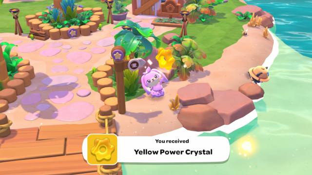 A pink bunny player obtaining a yellow power crystal in Hello Kitty Island Adventure.