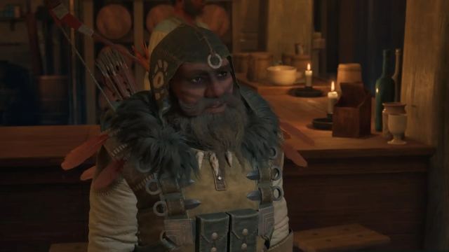 A dwarf in a hood with a long beard and face paint speaks.
