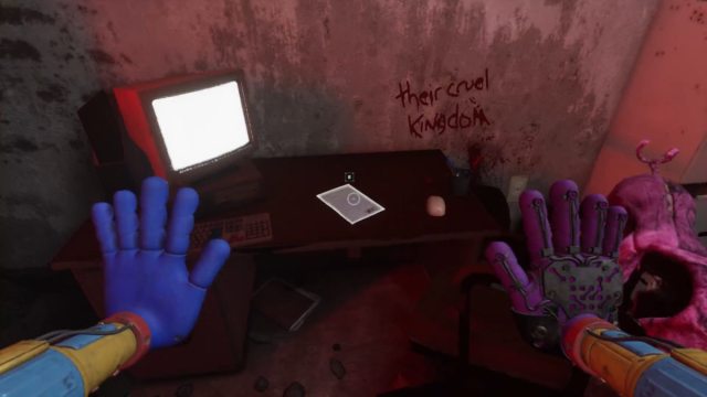 Looking at a desk with a switched on computer on the left side of it, a dead Critter on the right, and the words "my cruel kingdom" written in blood on the wall