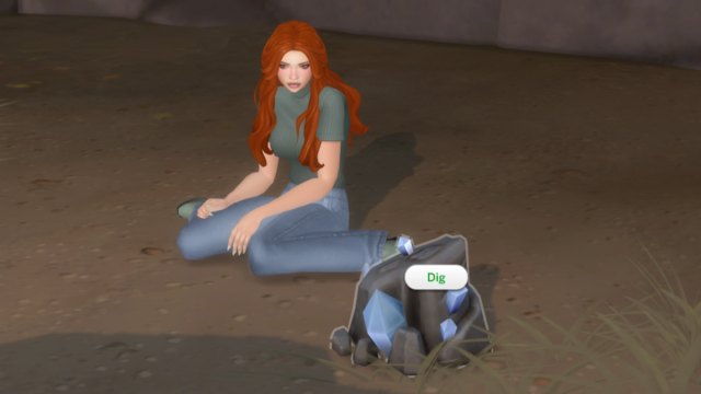 A Sim with orange hair, a sage green shirt, and jeans sitting by a rock spot with the Dig option on it in The Sims 4.