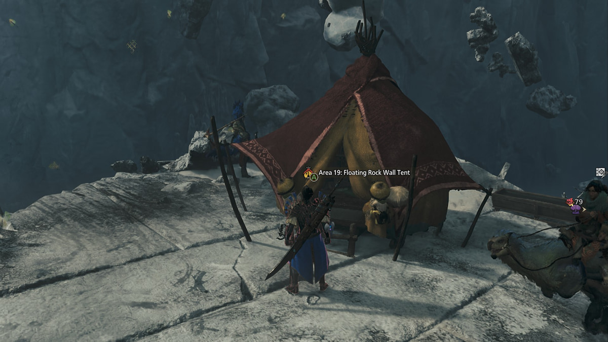 A hunter stands in front of a small tent set up on a mountain cliff.