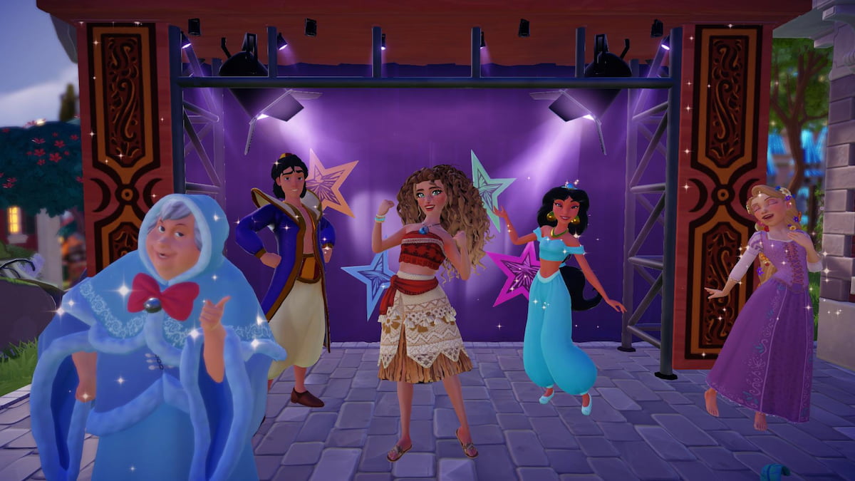A player with brown and blonde curly hair wearing a orange and light tan island dress standing with Aladdin, Jasmine, Rapunzel, and Fairy Godmother in front of a stage in Disney Dreamlight Valley.