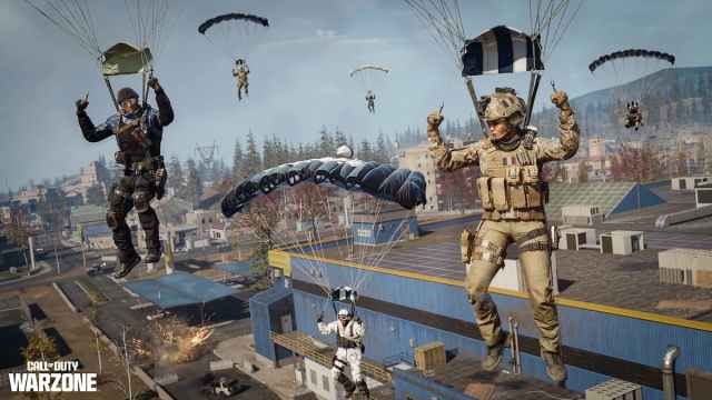 Numerous soldiers parachuting over a row of houses and buildings in COD Warzone.